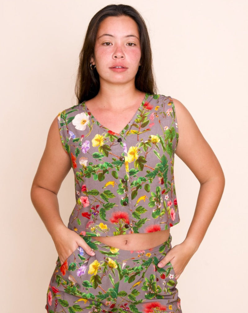Women's Mohala Croppec Vest featuring botanical illustrations of native Hawaiian flowers. Soft and comfortable bamboo fiber rayon. Sleeveless button-down top. Poi (purple) color.