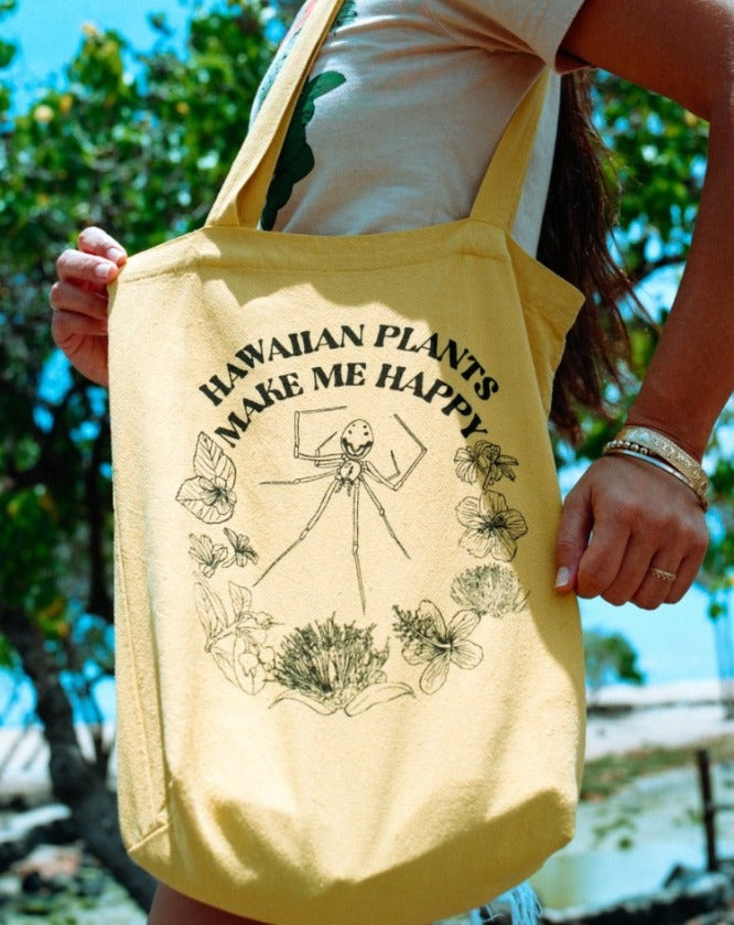 Hawaiian Happy face spider yellow everyday shopping tote bag with botanical tropical flowers and plants. Made in Hawaii. Linen and cotton blend. Mustard yellow color. Floral design. Screen printed.